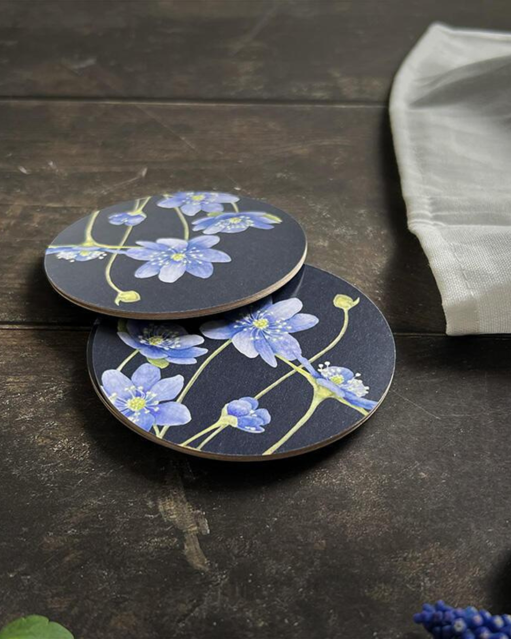 "Blaue Anemonen" Untersetzer mit schönem Motiv von Koustrup & co auf dunklen Holztisch.
