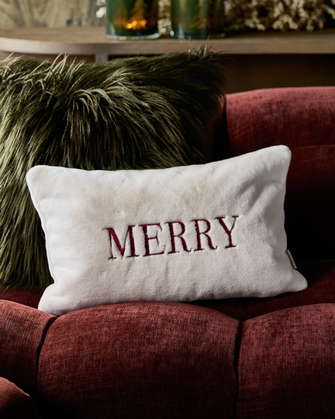 Merry-Kissen dekoriert auf rotem Sofa im Wohnzimmer