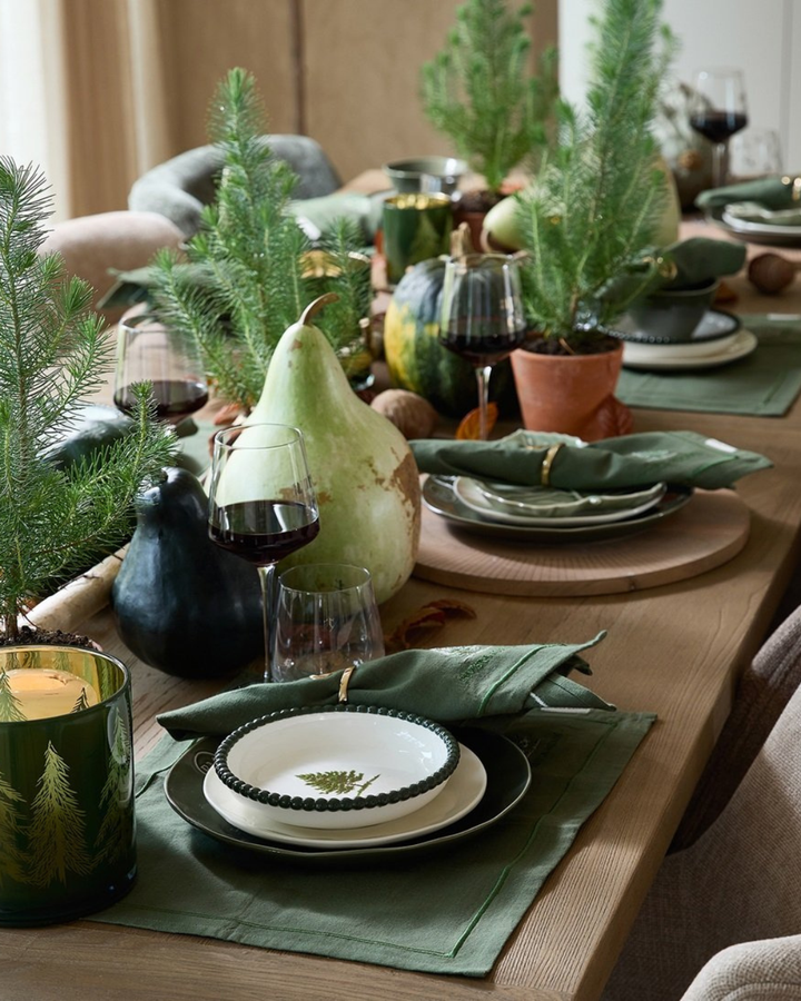 Festliche Wintertafel mit Woodlands Tree Bowl und grüner Naturdeko von Rivièra Maison.