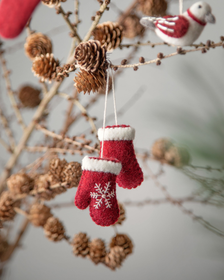 Filz-Fäustlinge mit Stickerei am Zweig hängend
