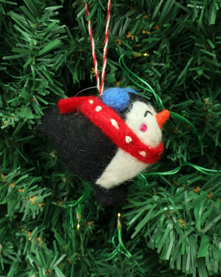 Dekorierter Weihnachts-Pinguin Filzanhänger"Pia" von Grace & Gloria. Der Süße Pinguin Ahnänger ist schwarz weiß und trägt einen roten Schal mit weißen Pünktchen Schal.