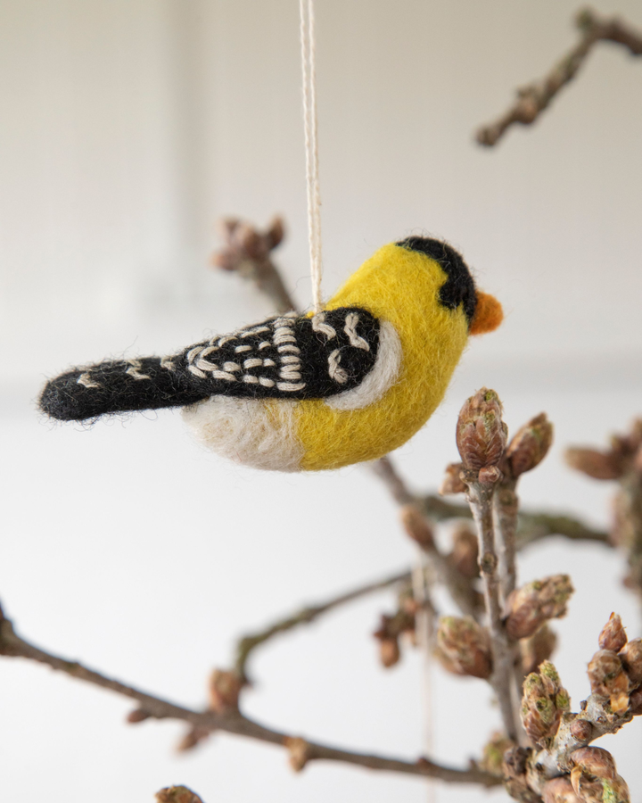 Goldzeisig Filzanhänger von Gry & Sif als handgefilzter Vogel an einem Zweig dekorativ aufgehängt