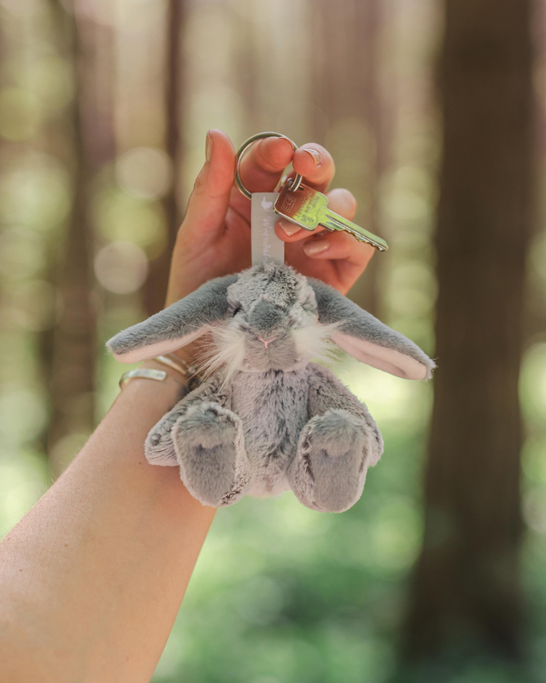 Hase Schlüsselanhänger Rosie von Wrendale Designs am Schlüsselbund in der Hand gehalten, grauer Plüschhase
