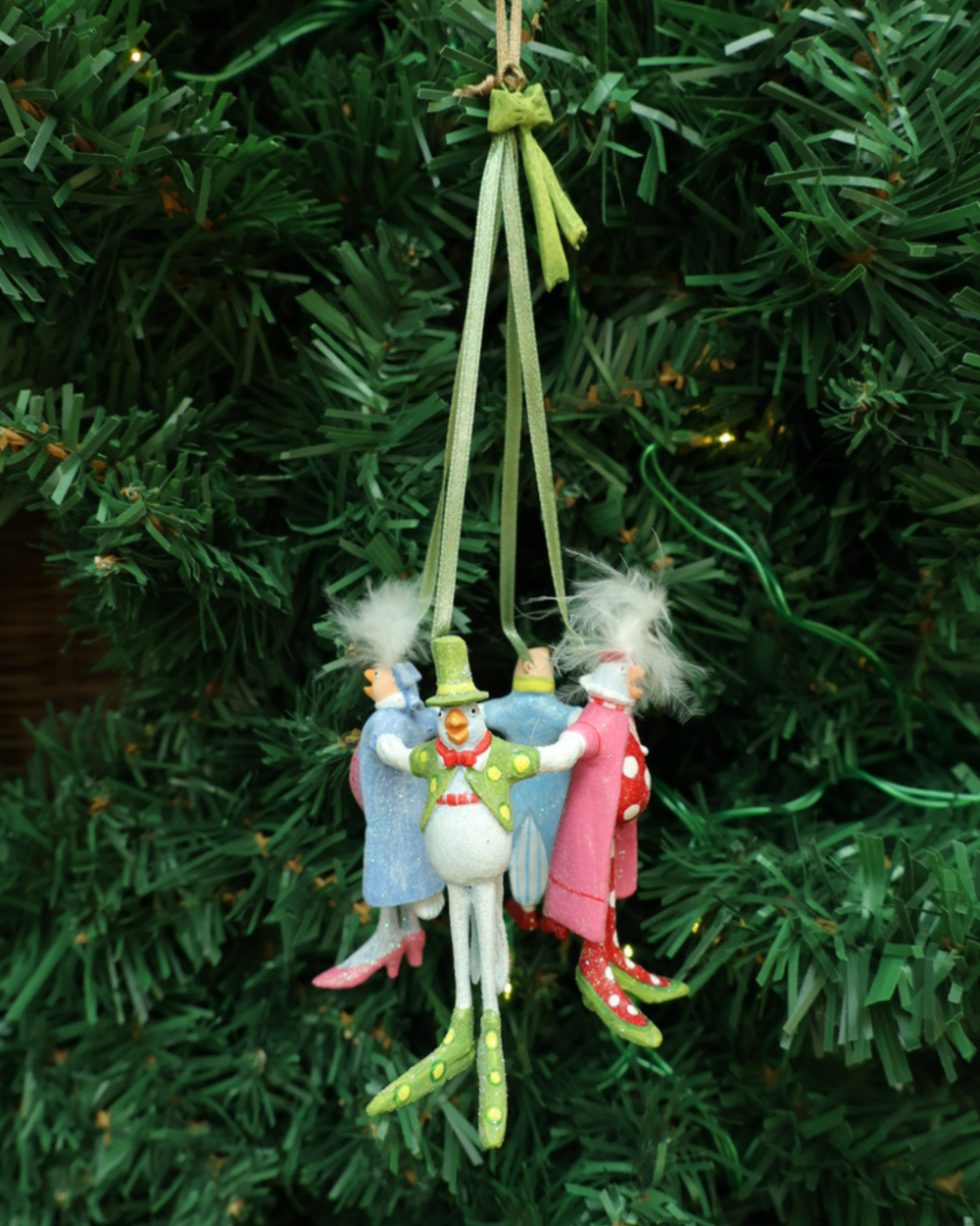 Weihnachts Ornaments "12 Days 4 Calling Birds" von Patience Brewster vor weißen Hintergrund.Das Ornament besteht aus 4 kleinen unten Männchen mit ganz unterschiedlicher Kleidung. Hängen auf einem Tannenbaum.