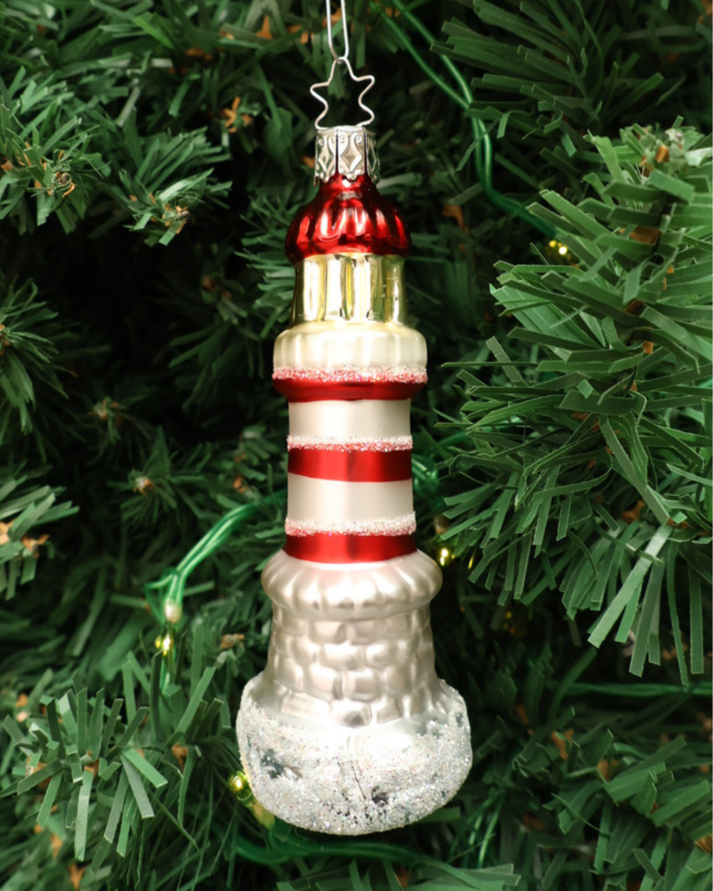 Weihnachtliches Leuchtturm Ornament von Inge Glas in Tannengrün hängend.