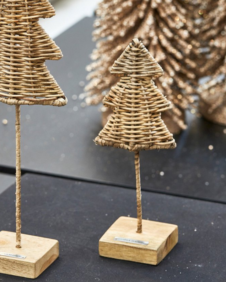 Weihnachtsdekoration mit Rustic Rattan Weihnachtsbaum „Christmas Tree“ von Rivièra Maison auf einem schwarzen Tisch.