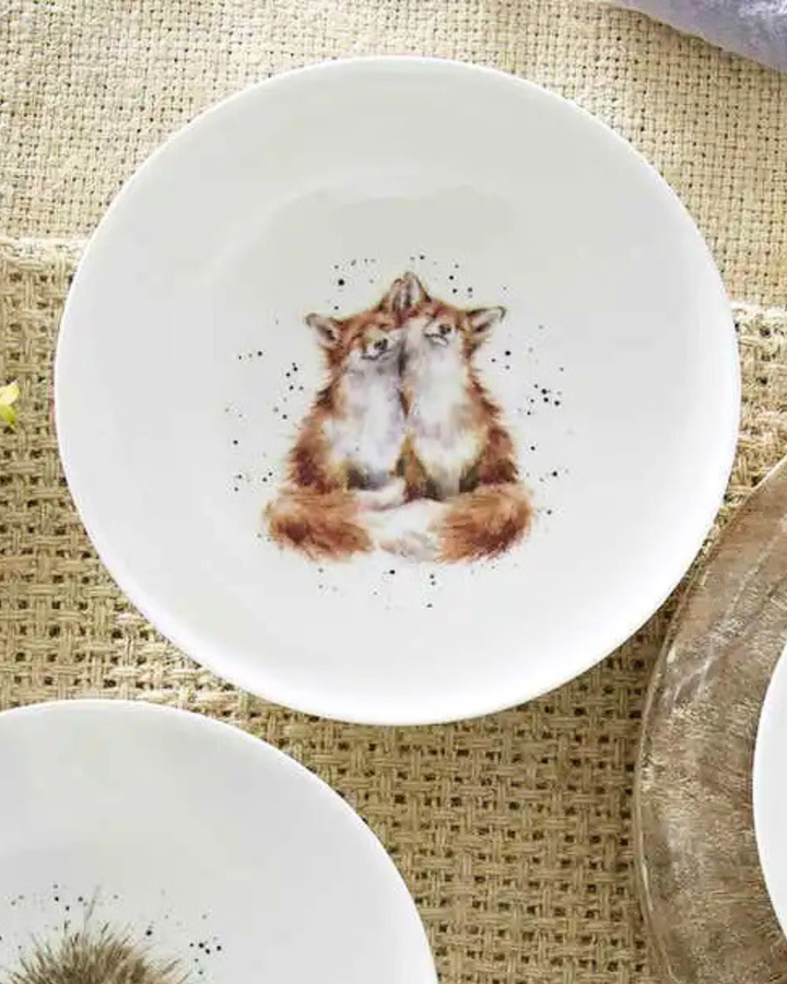 Weißes Fuchs Schüsselchen "Royal Worchester" aus Porzellan von Wrendale Designs auf bedeckten Tisch. Das Motiv zeigt 2 kuschelnde Füchse. 