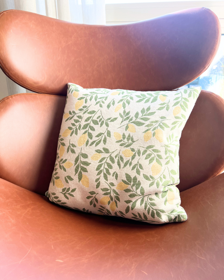 In einem braunen Ledersessel dekoriertes Lemonie Kissen mit Zitronen-Motiv von Sander.
