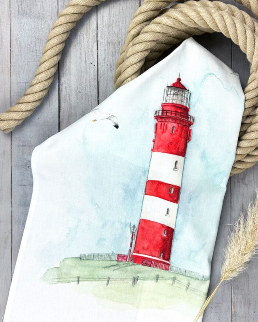 Leuchtturm Geschirrtuch Red Lighthouse von Maluu dekorativ mit Seil und Küstenaccessoires inszeniert