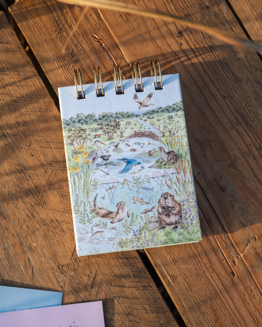 Vorderseite des Mini Notiz- und Skizzenbuchs „Riverbank“ mit detailreicher Illustration einer Flusslandschaft.