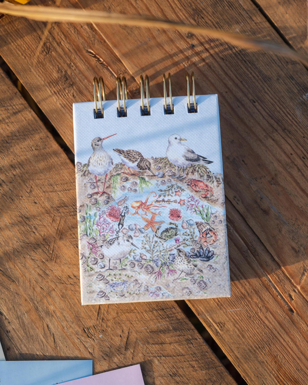 Mini Notiz- und Skizzenbuch „Seaside“ von Wrendale Designs mit maritimen Tierillustrationen auf einem Holztisch.