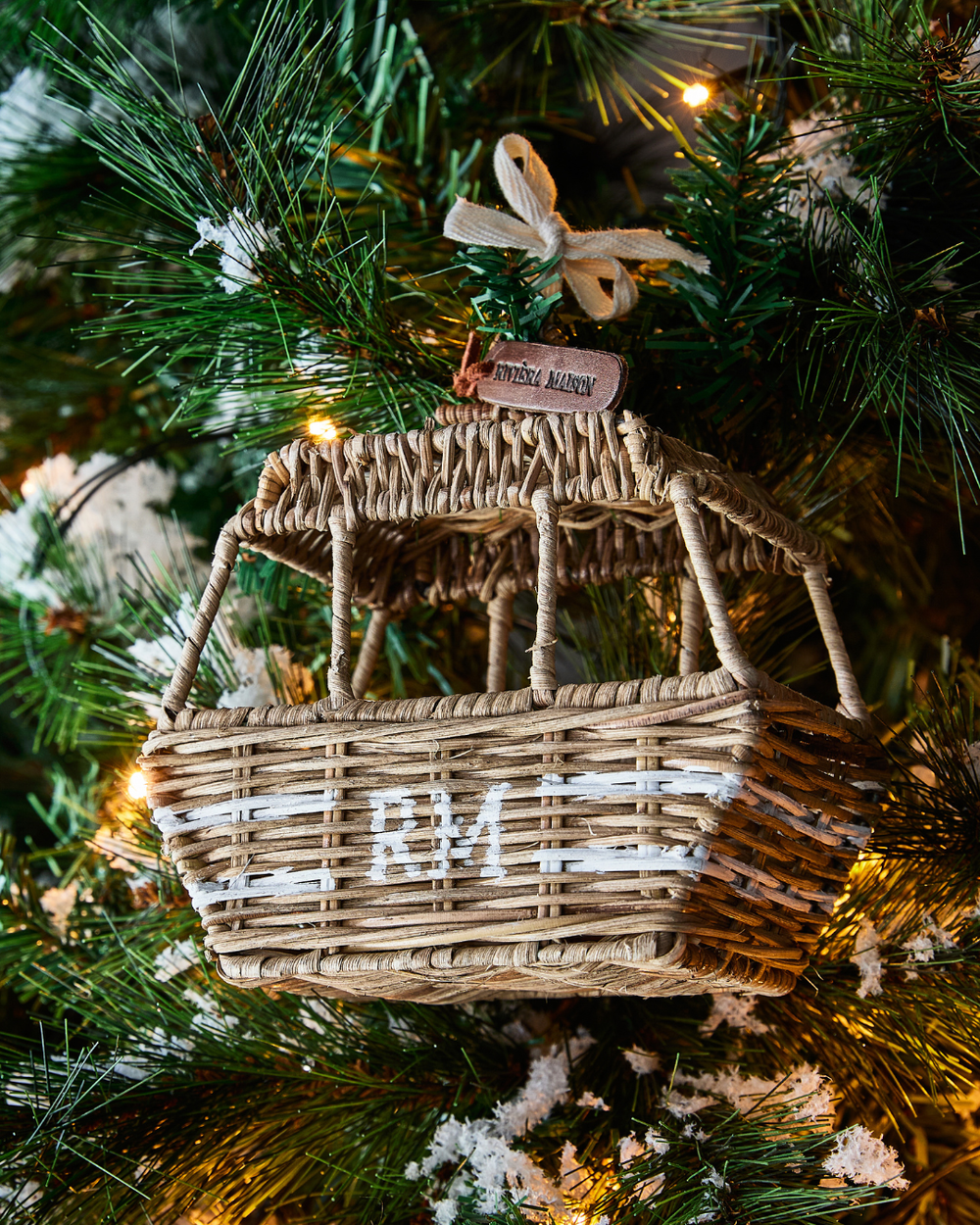 Rustic Rattan Ski Lift Ornament von Rivièra Maison, kleine handgeflochtene Rattan-Skigondel mit RM-Schriftzug, dekoriert im Weihnachtsbaum mit einer Lichterkette.