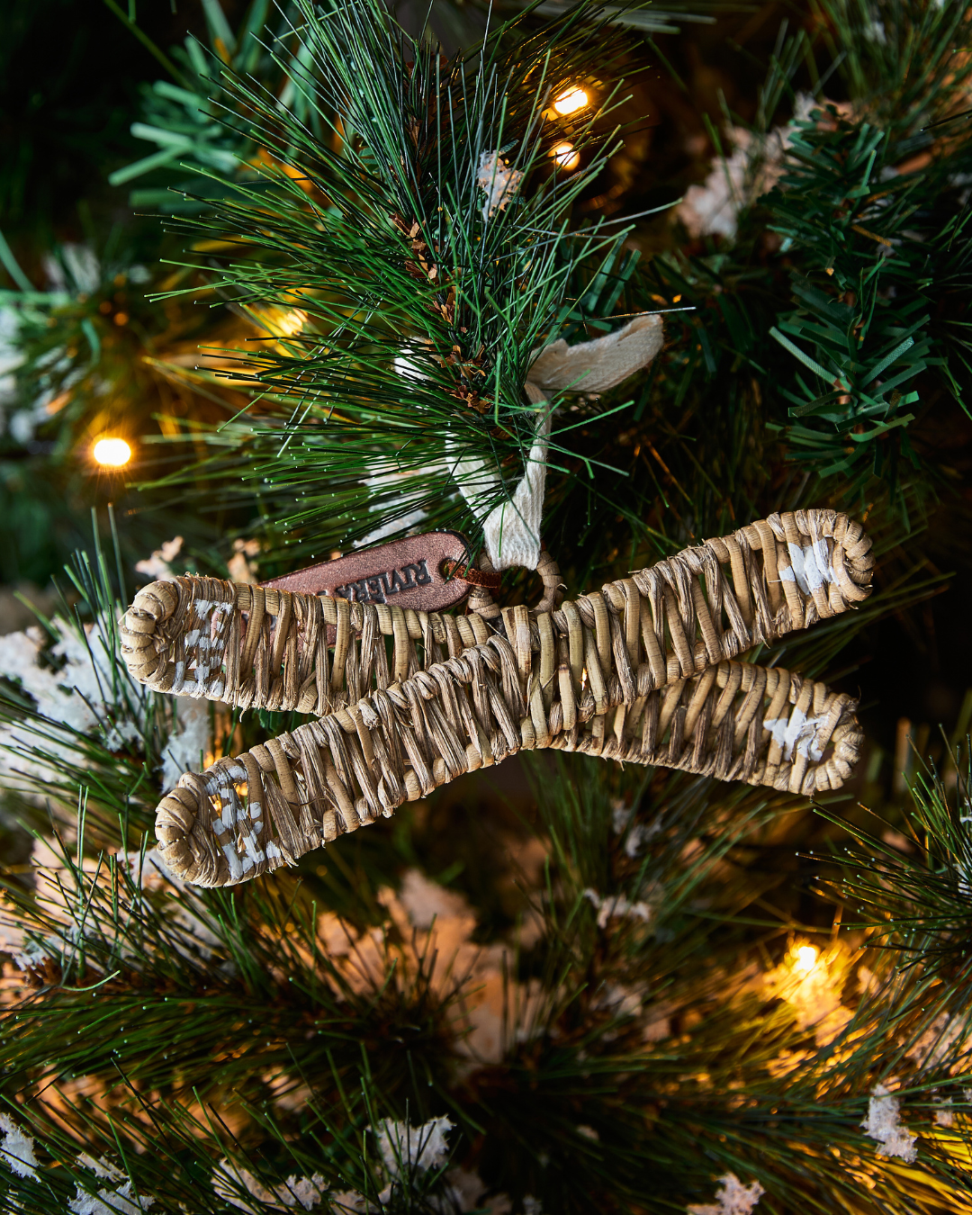 Rustic Rattan Skies Ornament von Rivièra Maison, kleine handgeflochtene Rattan-Ski, dekoriert im Weihnachtsbaum mit einer Lichterkette.