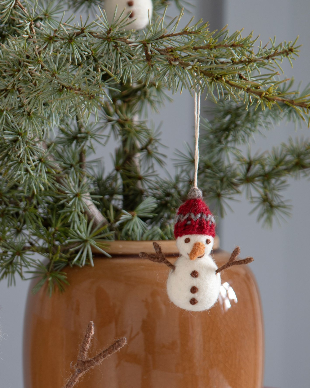 Schneemann Filzanhänger von Gry & Sif am Zweig hängend