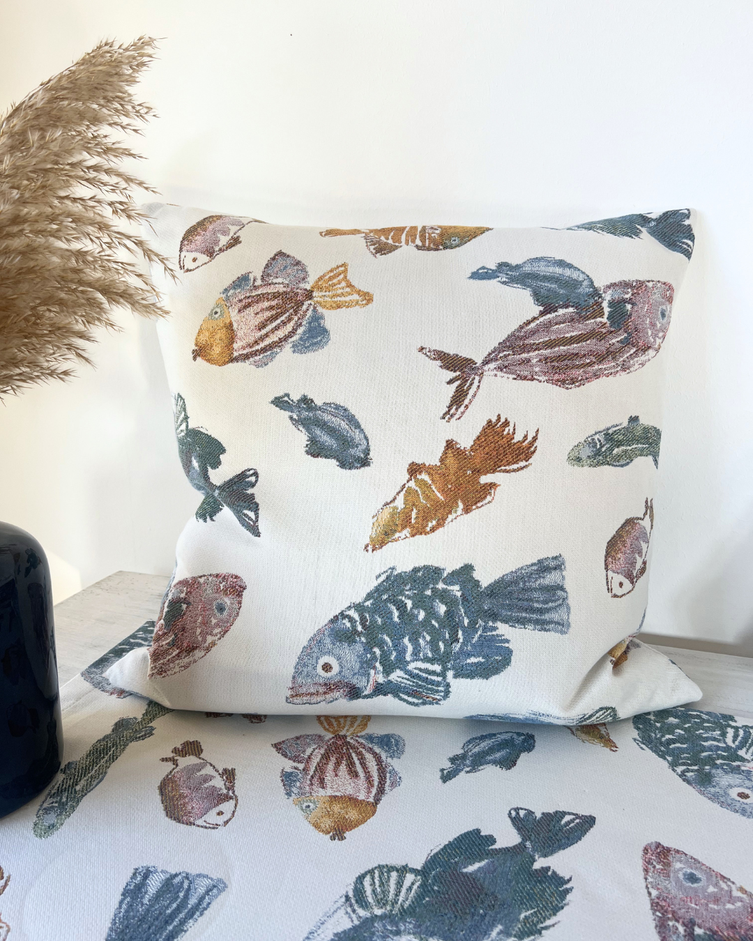 Glup Kissen von Sander mit vielen Fischen als Motiv dekoriert auf einem Tisch.