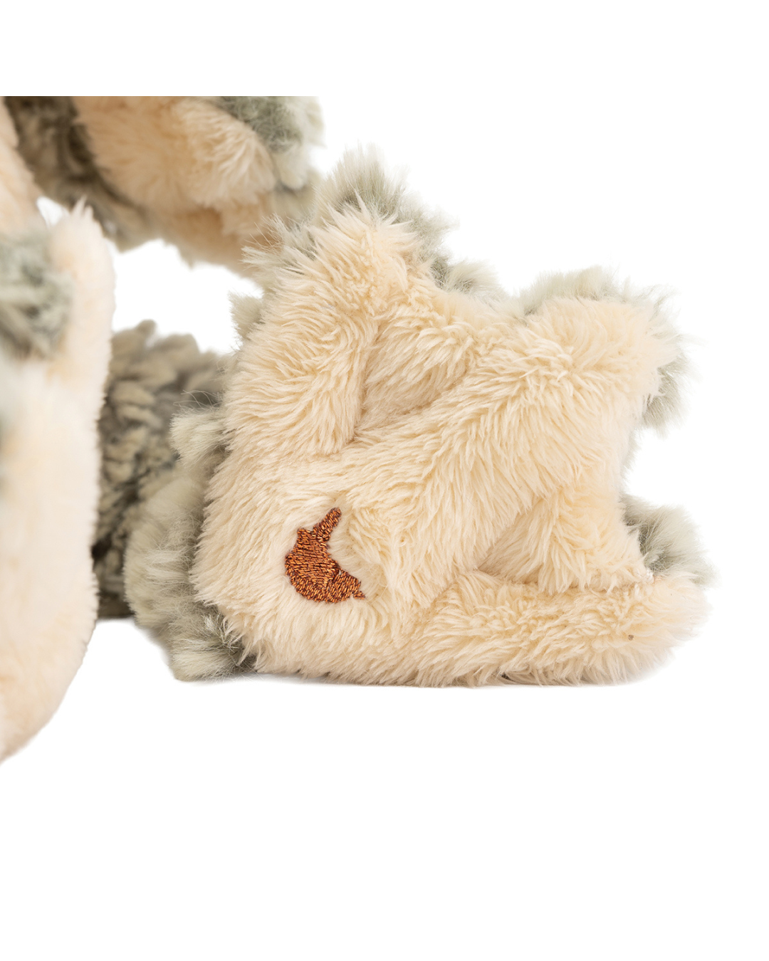Detailaufnahme der Pfote vom Frosch Kuscheltier „Elliott“ von Wrendale Designs mit gesticktem Wrendale-Hasenlogo auf hellem Plüsch.