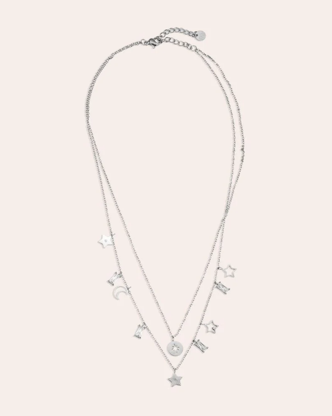 von einer Puppe getragene Doppellagige Kette mit Sternen und Mond von Dottilove in Silber. Die Kette ist größtenteils Silber mit Stern und Mond Anhängern und weißen Steinen.
