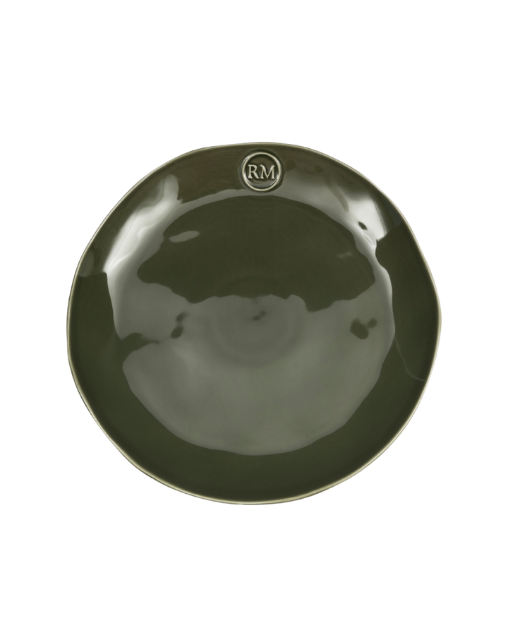 Dunkelgrüner Essteller Portofino von Rivièra Maison mit organischer Form und RM-Emblem vor weißem Hintergrund.