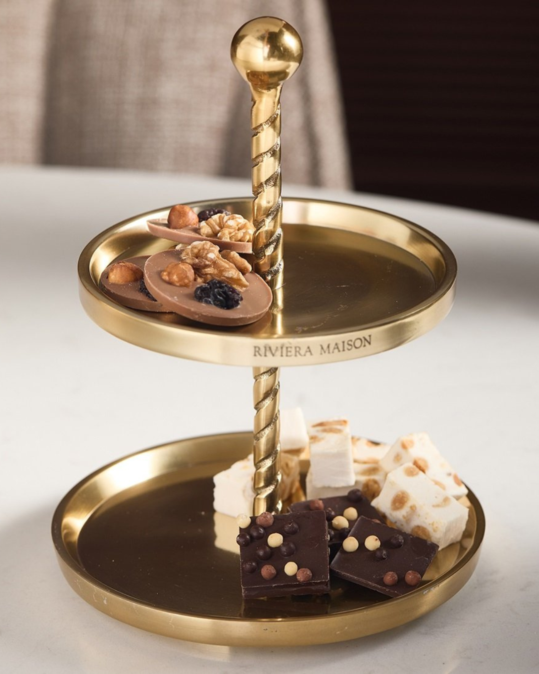 „Etagère Fallon von Rivièra Maison dekoriert mit Pralinen auf Tisch“