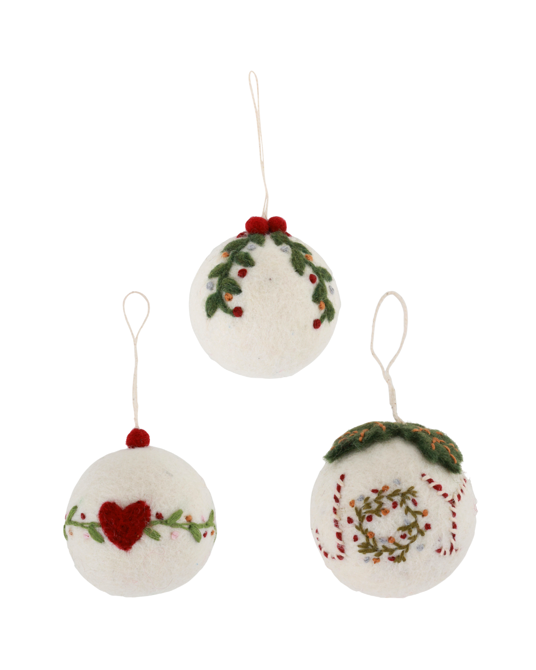 Drei handgefertigte Weihnachtsbaumkugeln aus weißem Filz von Gry & Sif, nebeneinander präsentiert vor weißem Hintergrund. Links Kugel mit Herzmotiv, in der Mitte Kugel mit Girlandenmotiv, rechts Kugel mit Joy-Motiv und Kranzstickerei.