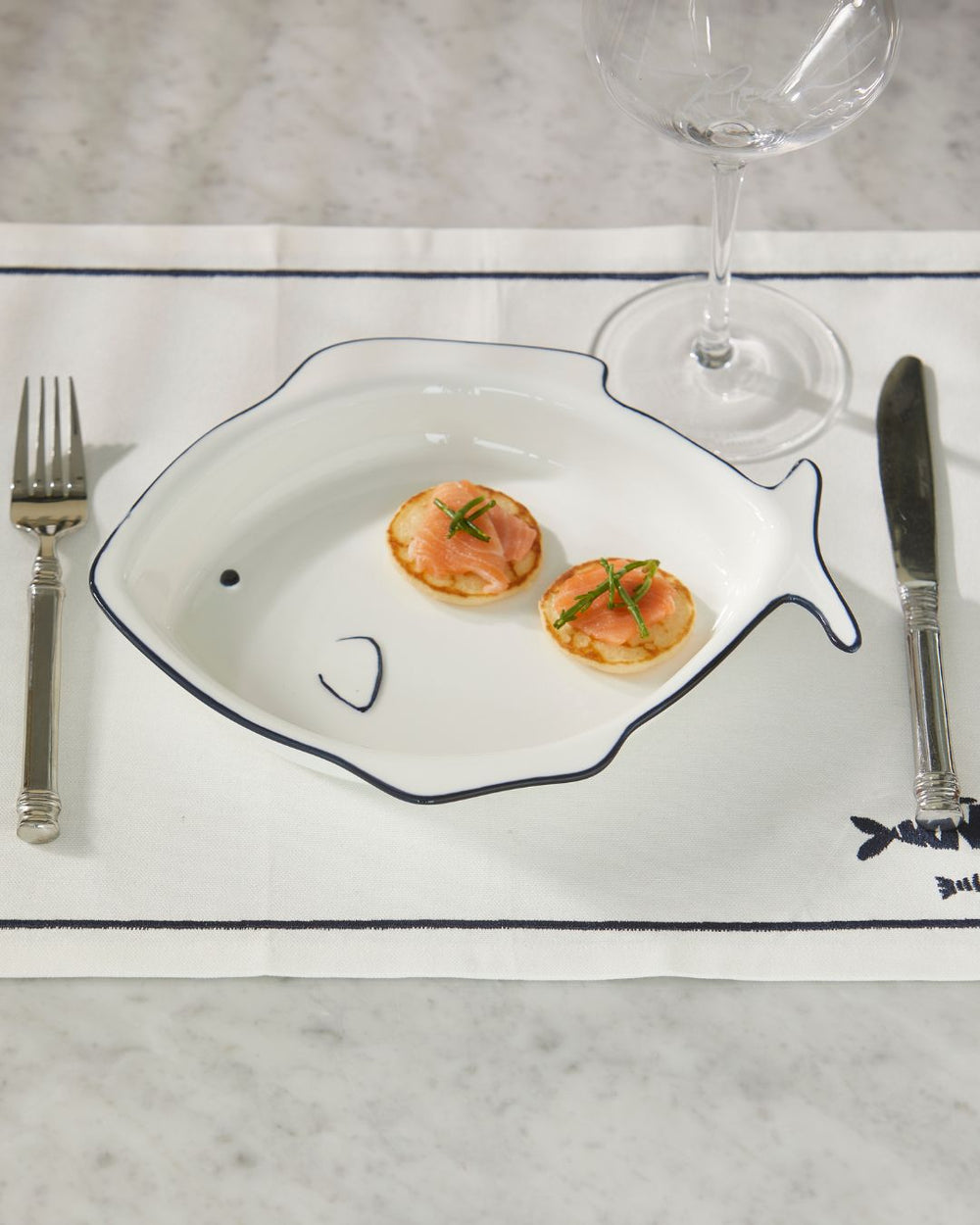 Fisch Servierplatte Como Catch von Rivièra Maison auf einem Marmortisch dekoriert.