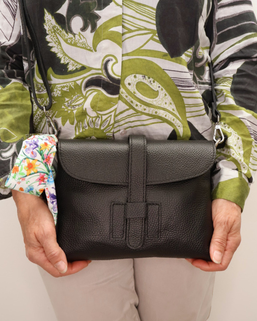 Frontal gehaltene schwarze Handtasche "Isabelle". Die Textur des Leders ist gut erkennbar. 