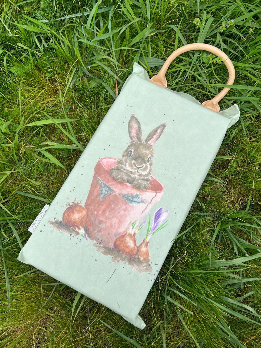 Garten-Kniekissen „Gartenbewohner“ von Wrendale Designs mit Tierillustrationen von Hannah Dale, liegend auf Gras dargestellt