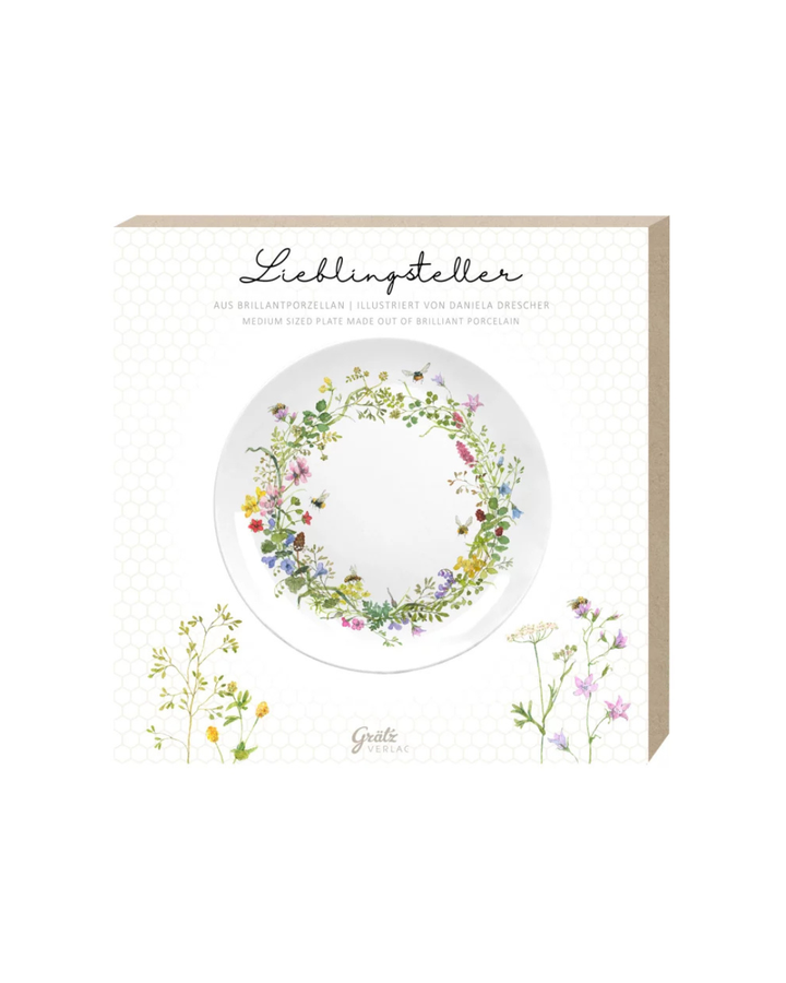 Geschenkverpackung des Frühstückstellers Wilde Bienen mit floralen Motiven und Illustrationen von Daniela Drescher vor weißem Hintergrund.