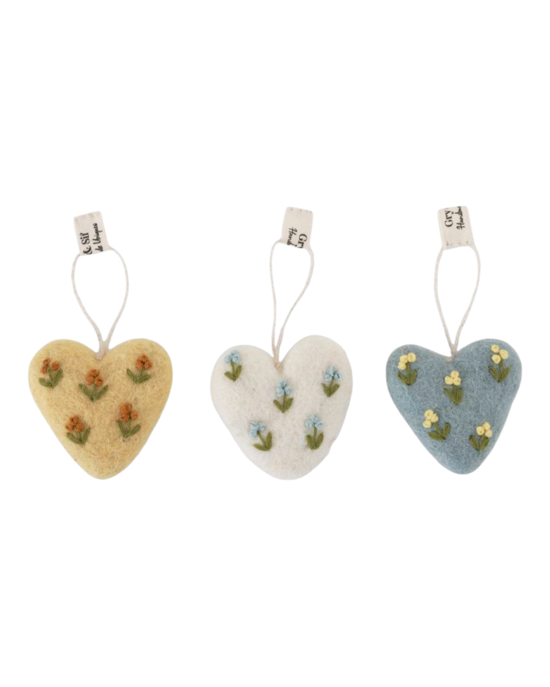 Drei große Filzherzen mit Blumenstickerei in Gelb, Creme und Blau von Gry & Sif vor weißem Hintergrund