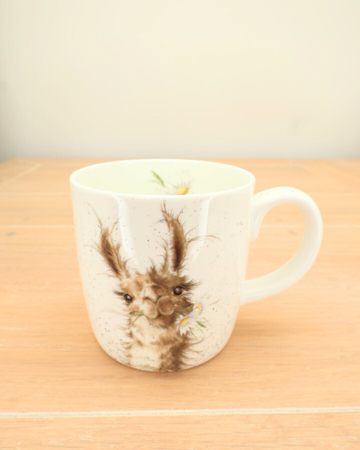Die große Lama-Tasse "I'm worth it" von Wrendale Designs steht auf einem Holztisch. Das Lama mit dem Blumenkranz ist gut zu erkennen.