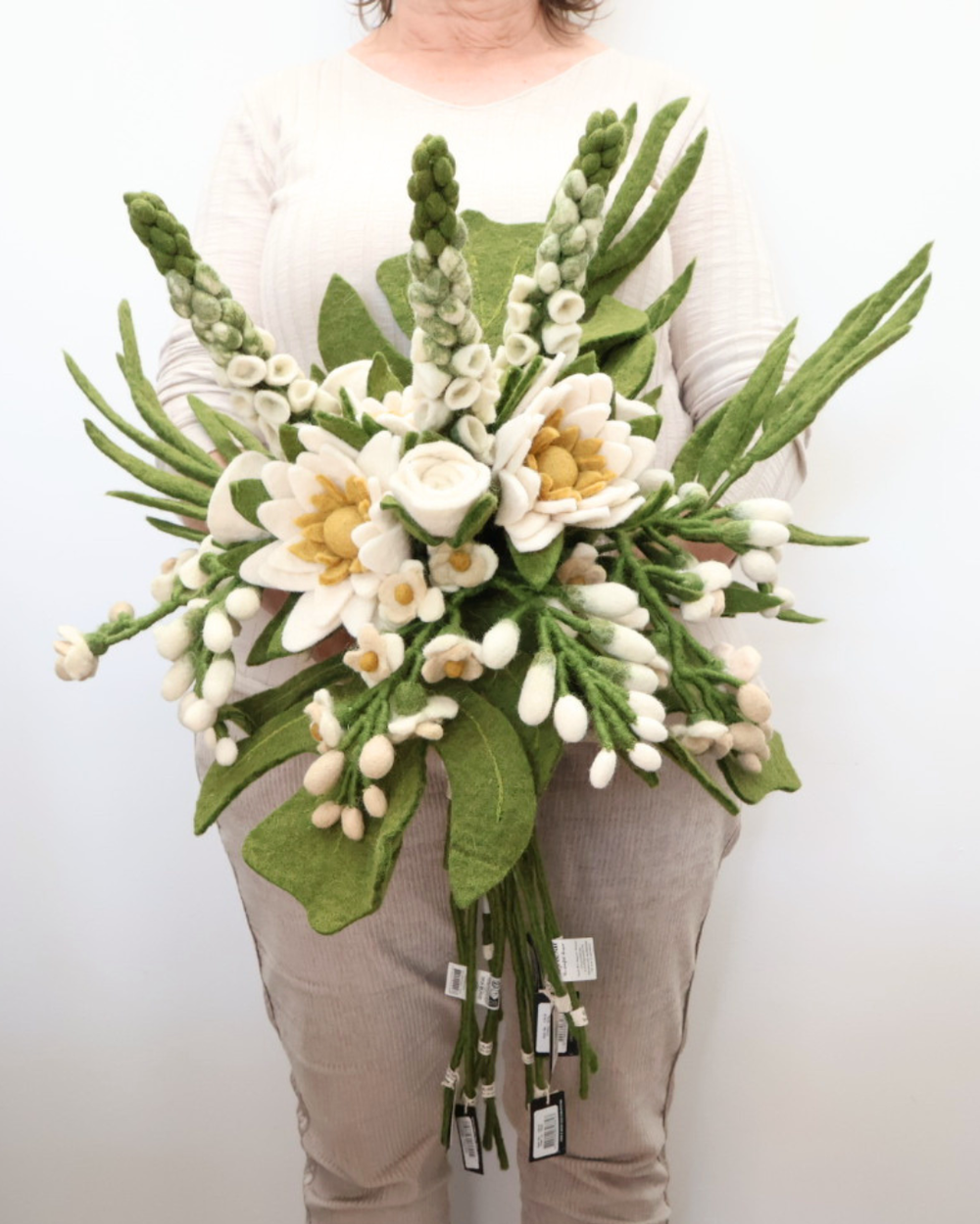 Bild zeigt den gesamten, üppigen Hochzeits-Blumenstrauß aus Filz mit cremefarbenen Rosen, Fingerhut (Digitalis), Schwertlilie (Iris hysteria), Wasserlilie (Nymphaea), Palmblättern, Wisteria (Blauregen) und Monstera (Fensterblatt).