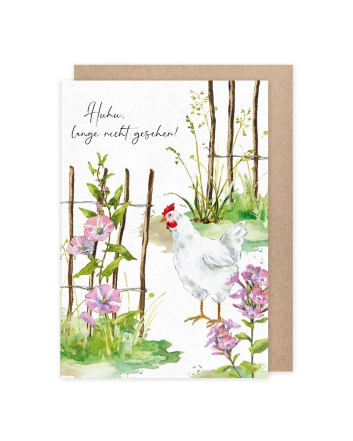 Die Grußkarte "Lange nicht gesehen" vom Grätz Verlag zeigt ein Huhn zwischen luftigen Zaunelementen, welche als Rankhilfe für rosafarbene Blumen dienen. Die Illustration von Daniela Drescher wird durch den Ausruf "Huhu, lange nicht gesehen!" vervollständigt, welcher oben  links auf der Karte geschrieben steht.