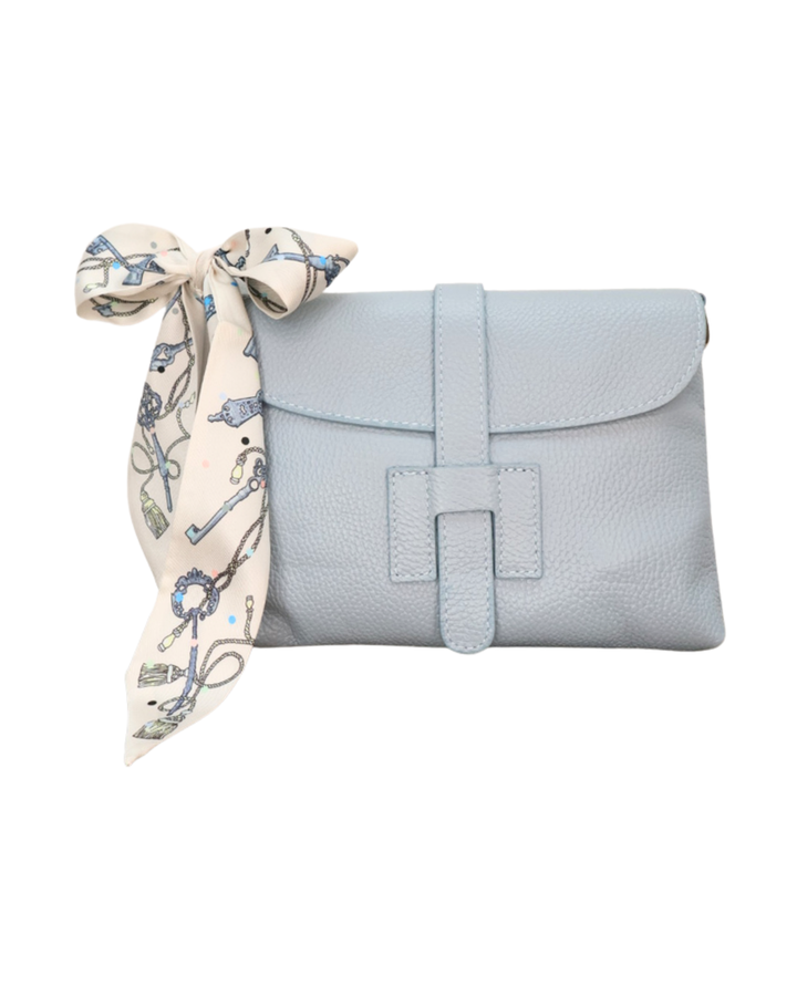 Frontansicht der hellblauen Ledertasche "Isabella" vom Südstrand mit kunstvollem blauen Bandana vor weißen Hintergrund.