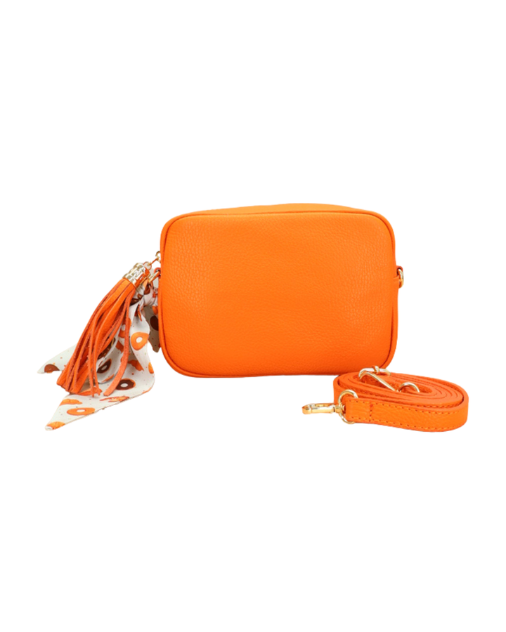 Orangenfarbene Lederhandtasche „Isolde“ mit Bandana-Anhänger am Reißverschluss, von vorne fotografiert.