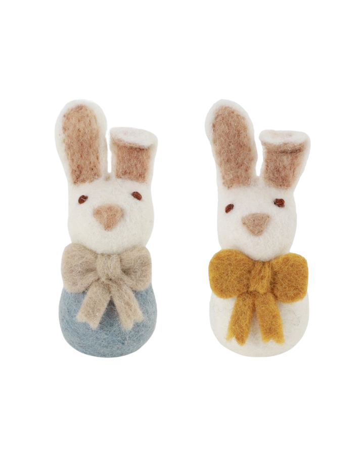 Zwei Filzhasen mit Schleife von Gry & Sif, einer mit hellblauem Körper und beiger Schleife, der andere mit weißem Körper und gelber Schleife, freigestellt vor weißem Hintergrund.