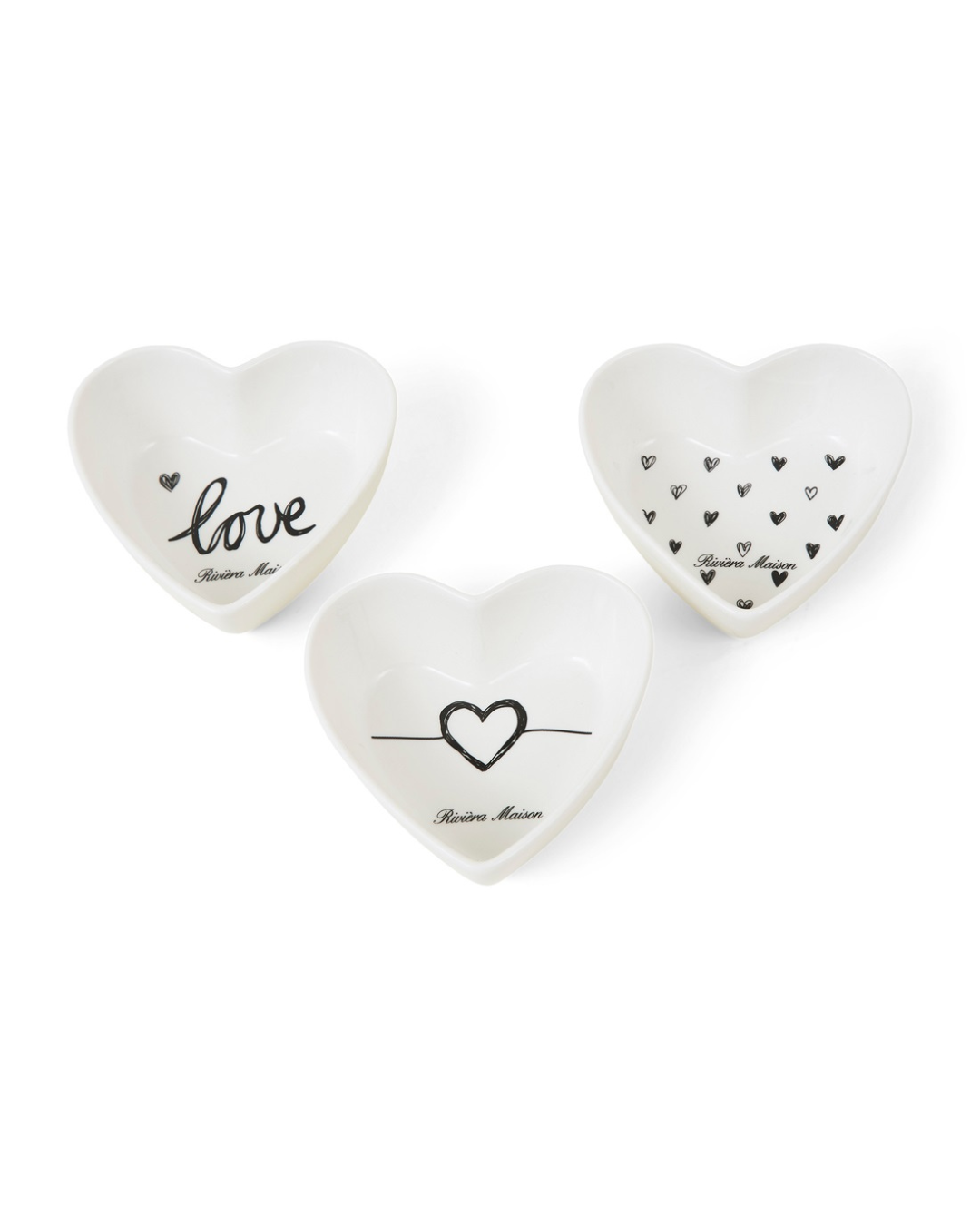 Drei weiße herzförmige Porzellanschälchen von Rivièra Maison mit unterschiedlichen schwarzen Herz- und Schriftmotiven, freigestellt vor weißem Hintergrund.