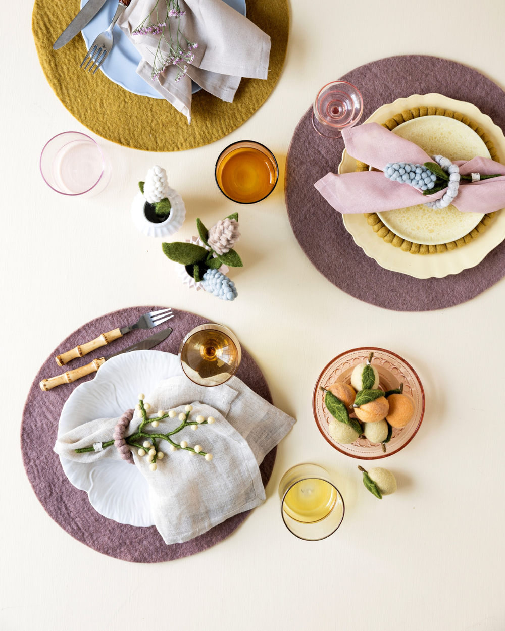 Filzblumen von Gry & Sif mit Hyazinthe und Beerenast als dekorativer Akzent auf einem gedeckten Tisch.