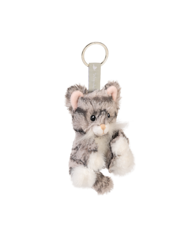 Getigerter Katzen Schlüsselanhänger Esmeralda von Wrendale Designs, an einem Schlüsselring befestigt und in einer Hand gehalten, vor unscharfem grünen Hintergrund im Freien.