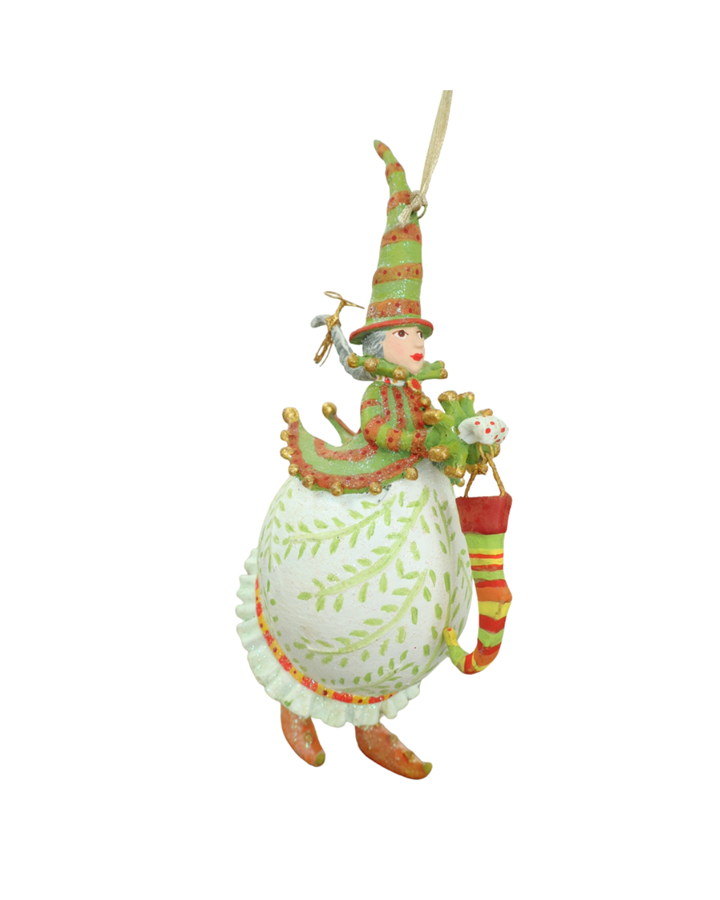 Krinkle "Mrs Santa With Stocking Ornament" von Patience Brewster vor weißen Hintergrund. Sie ist weiß und grün gekleidet.