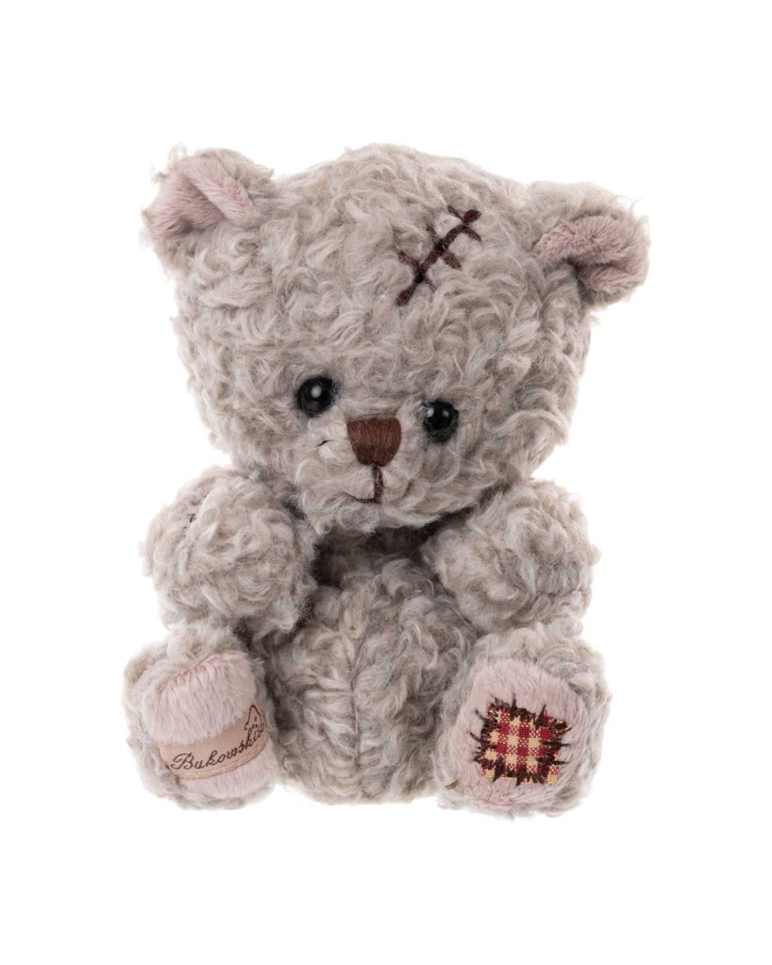 Kuscheltier Arnold von Bukowski mit grauem, zotteligem Fell und Flicken an der Pfote