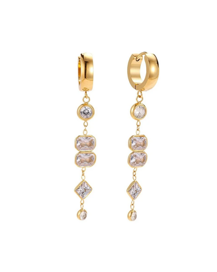 Lange Ohrringe mit weißen Zirkoniasteinen von Dottilove vor weißen Hintergrund. Die Ohrringe sind gold farbig am unteren ende ist eine Kette befestigt an denen die weißen Steine hängen. 