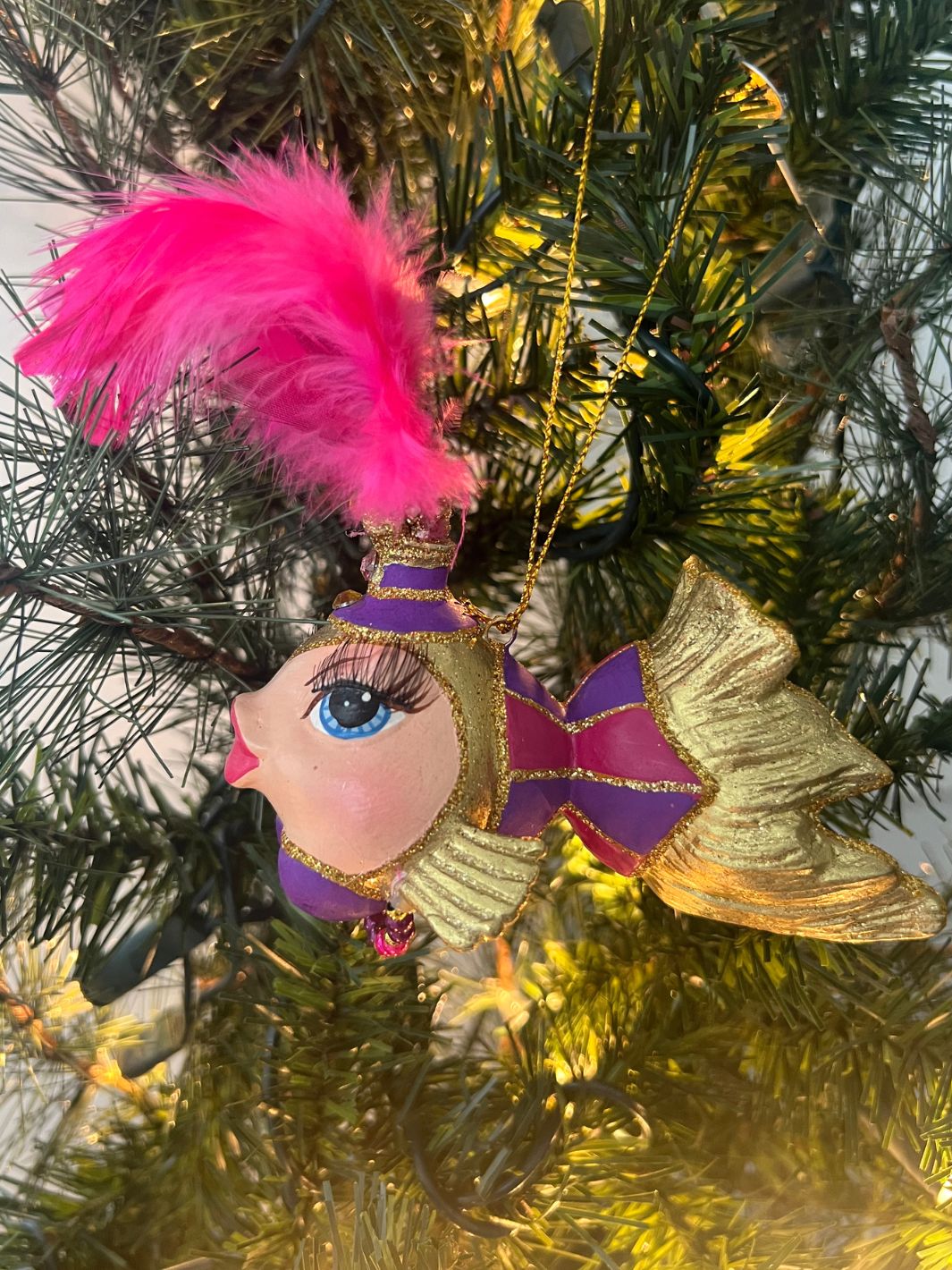 Fisch in Lila und Gold als Showgirl verkleidet für den Weihnachtsbaum von Goodwill.