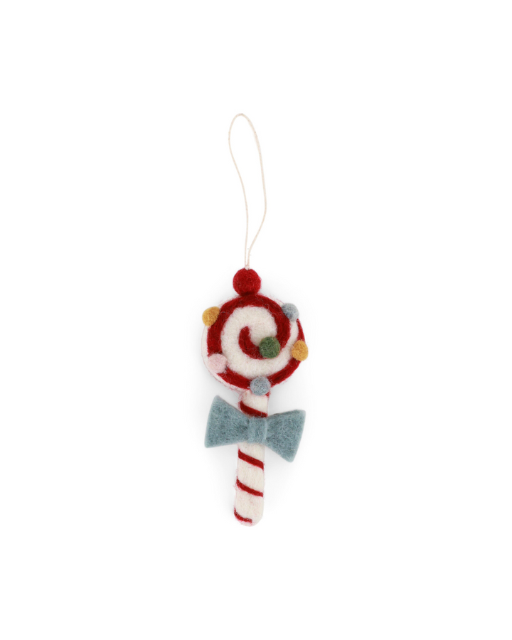 Handgefertigter Filzanhänger in Form eines Lutschers von Gry & Sif vor weißem Hintergrund. Der Lolli ist in Rot-Weiß mit Spiralmuster gestaltet, mit bunten Filzkügelchen verziert und trägt eine hellblaue Schleife am Stiel. Oben ist eine Schlaufe zum Aufhängen angebracht.