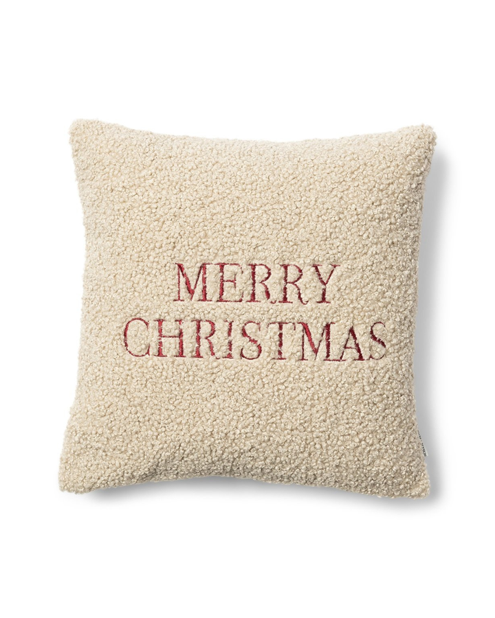 Cremefarbener Rivièra Maison Kissenbezug aus Teddystoff mit roter Merry Christmas Stickerei.