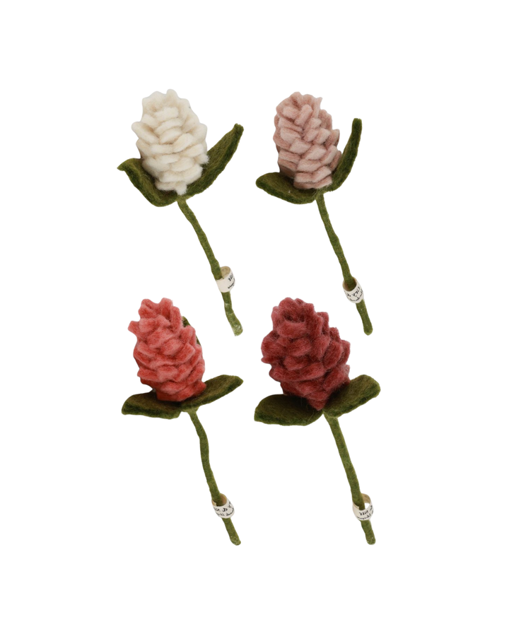 Vier Mini-Artischocken aus Filz von Gry & Sif in Weiß, Rosé, Koralle und Dunkelrot, freigestellt vor einem neutralen weißen Hintergrund. Die Filzblumen sind locker angeordnet, sodass Form, Farbe und die handgearbeitete Struktur jeder einzelnen Blüte gut erkennbar sind.