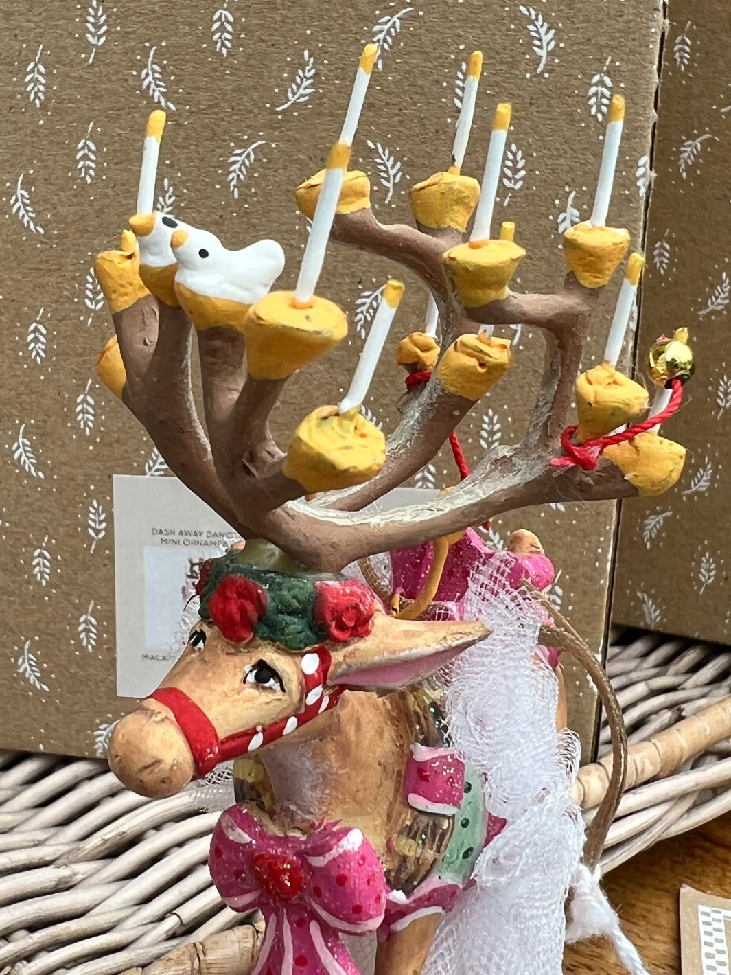 Kopf mit Blumenschmuck und Geweih mit Vögeln und Kerzen