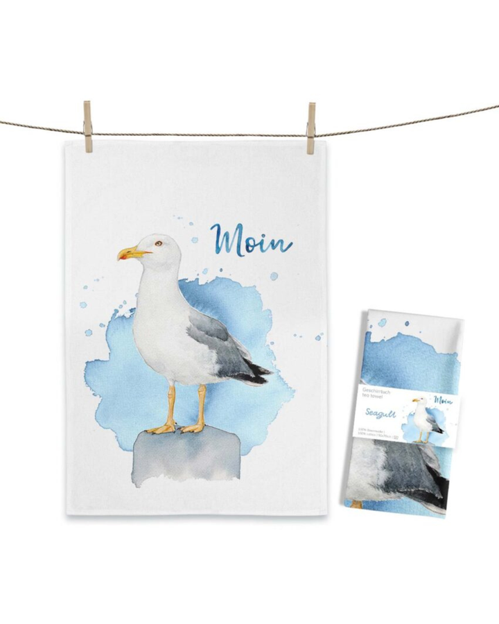 Möwen Geschirrtuch Seagull von Maluu mit gezeichneter Möwe auf blauem Aquarellhintergrund und Schriftzug Moin, aufgehängt an einer Leine