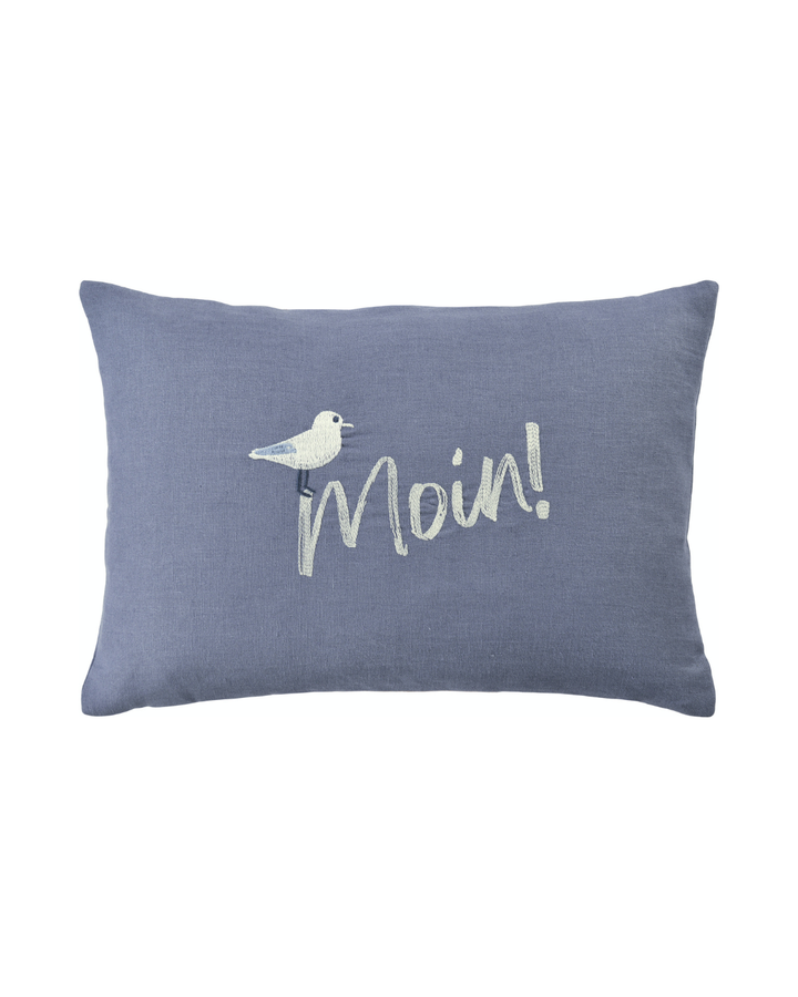 Dunkelblaues Leinen-Kissen von Sander mit aufgestickter Möwe und Moin-Schriftzug vor weißem Hintergrund.
