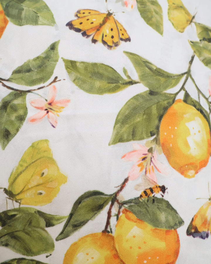 Motivaufnahme des Zitronenkissens "Fresh Lemons"  von Ambiente. Das Motiv ist größtenteils gelb und grün. Zu sehen sind Schmetterlinge, Zitronen, Blumen und Bienen.