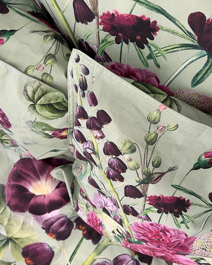 Bettwäsche-Set Blossom Garden: Kissen und Bettdecke mit üppigem Blumenmuster, dekoriert mit passendem Kissen.